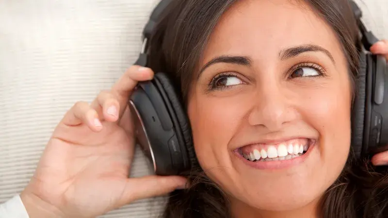 A woman listening to music with earphones because the machine sounds make her uneasy
