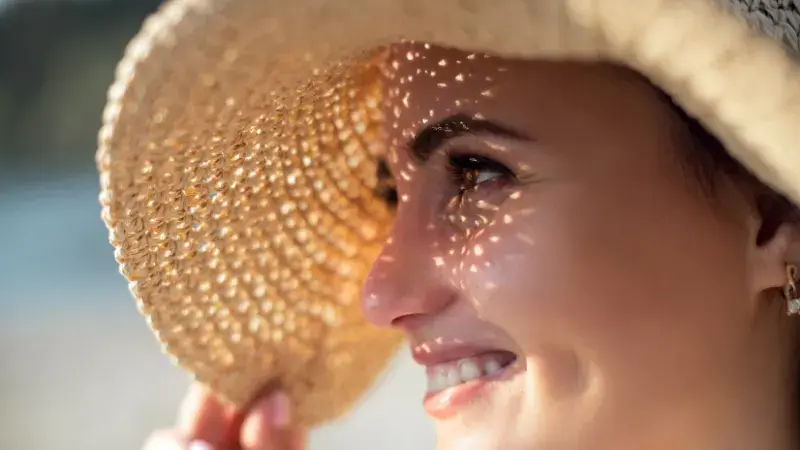 A woman avoiding the sun to protect her newly microbladed eyebrows