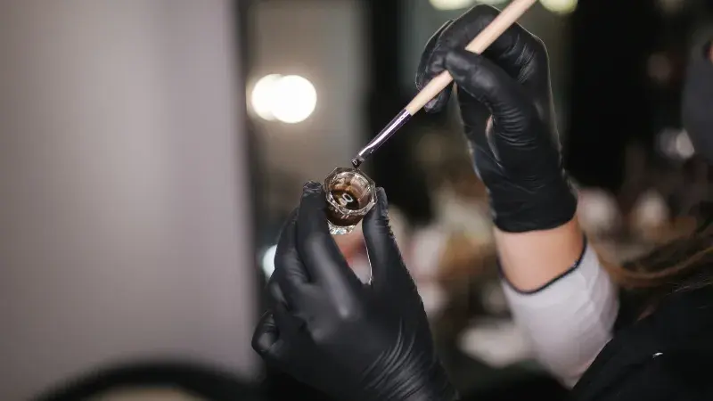 A beautician holding pigment for brows