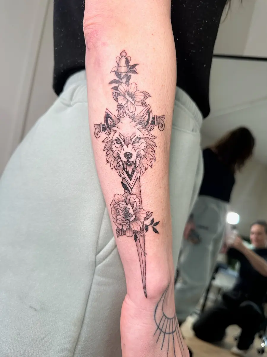 Fine line wolf and botanical tattoo on a forearm by Sophie, Devon studio serving Plymouth clients