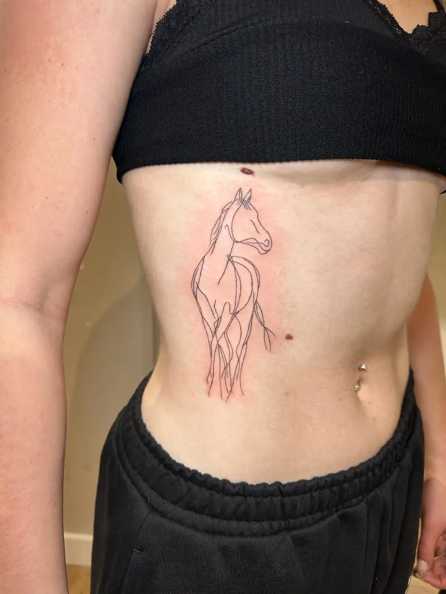 Fine line horse tattoo on the ribs by Sophie, Devon studio serving Torquay clients