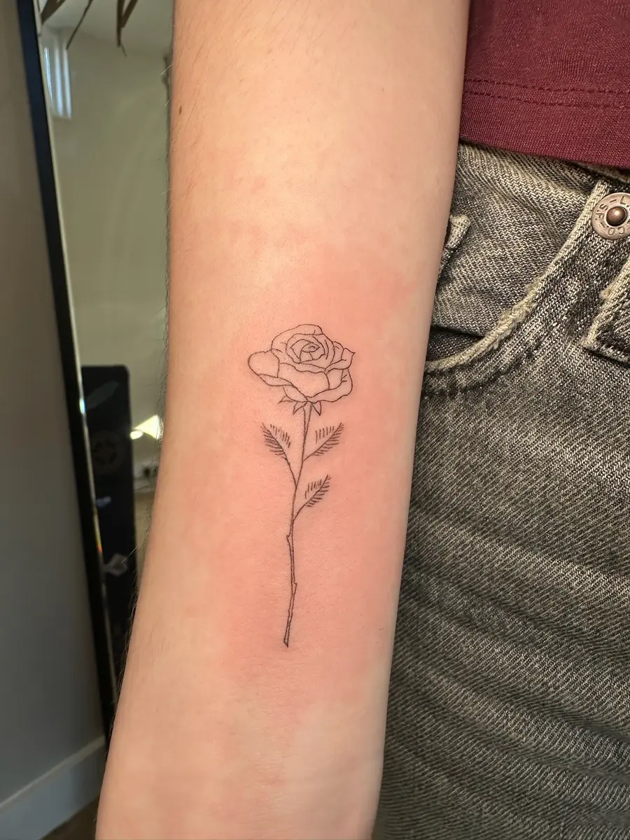Fine line rose tattoo on an upper arm by Sophie at Gemma Henderson PMU